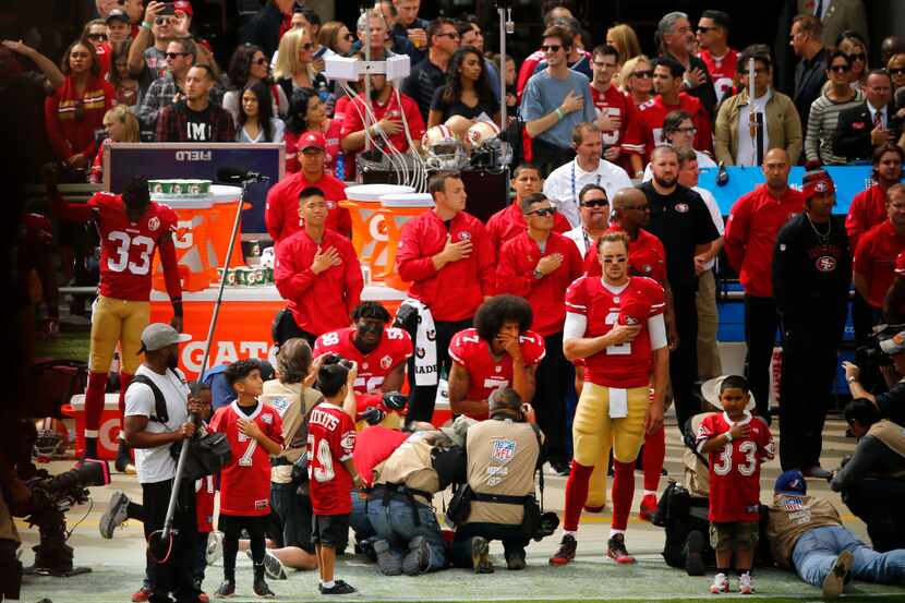 San Francisco 49ers quarterback Colin Kaepernick (7) takes a knee alongside outside...