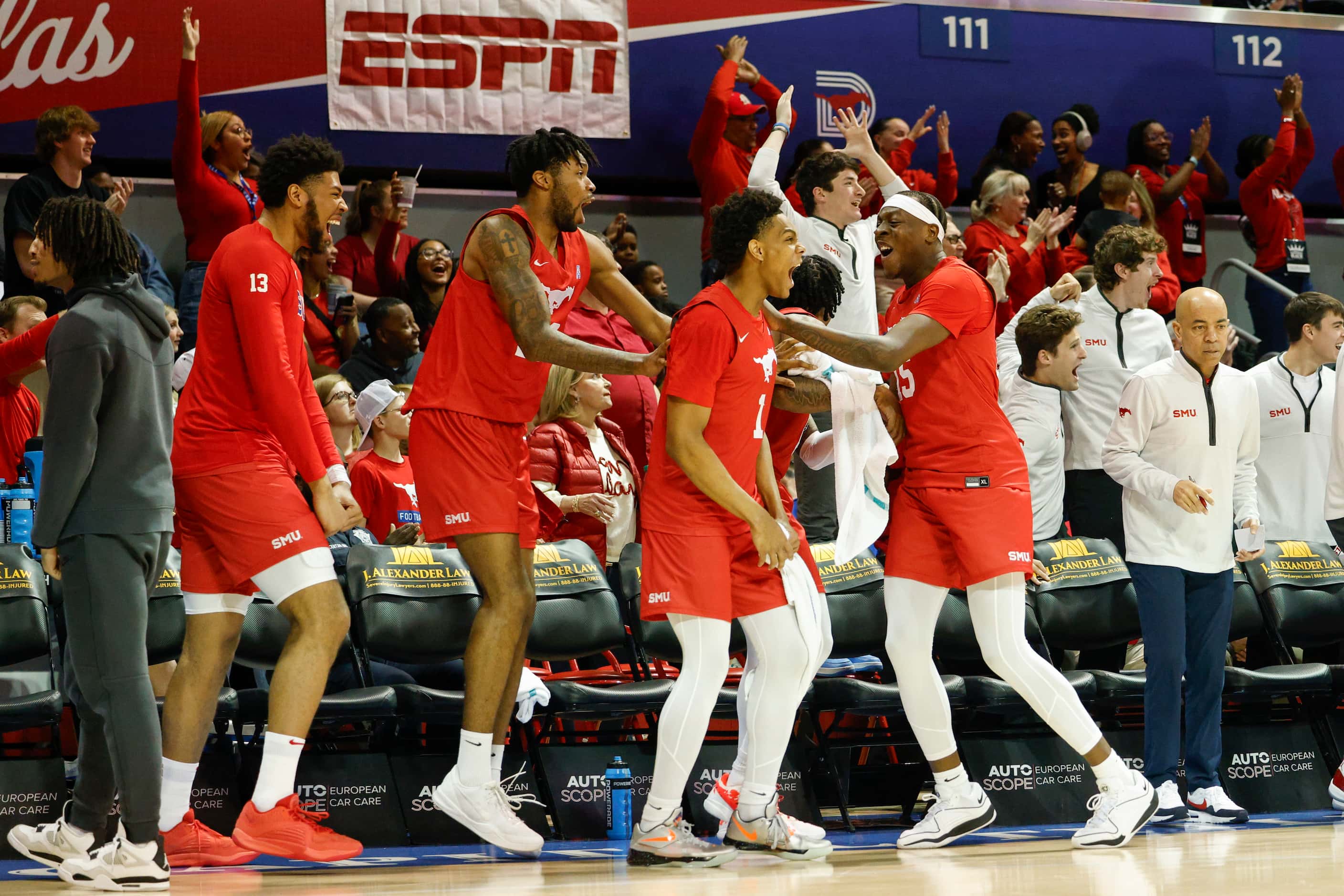 The SMU bench reacts after a dunk during the first half of an NCAA basketball game against...