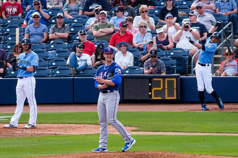 The 20-second pitch clock resets as Texas Rangers pitcher Kyle Bird rubs a baseball between...