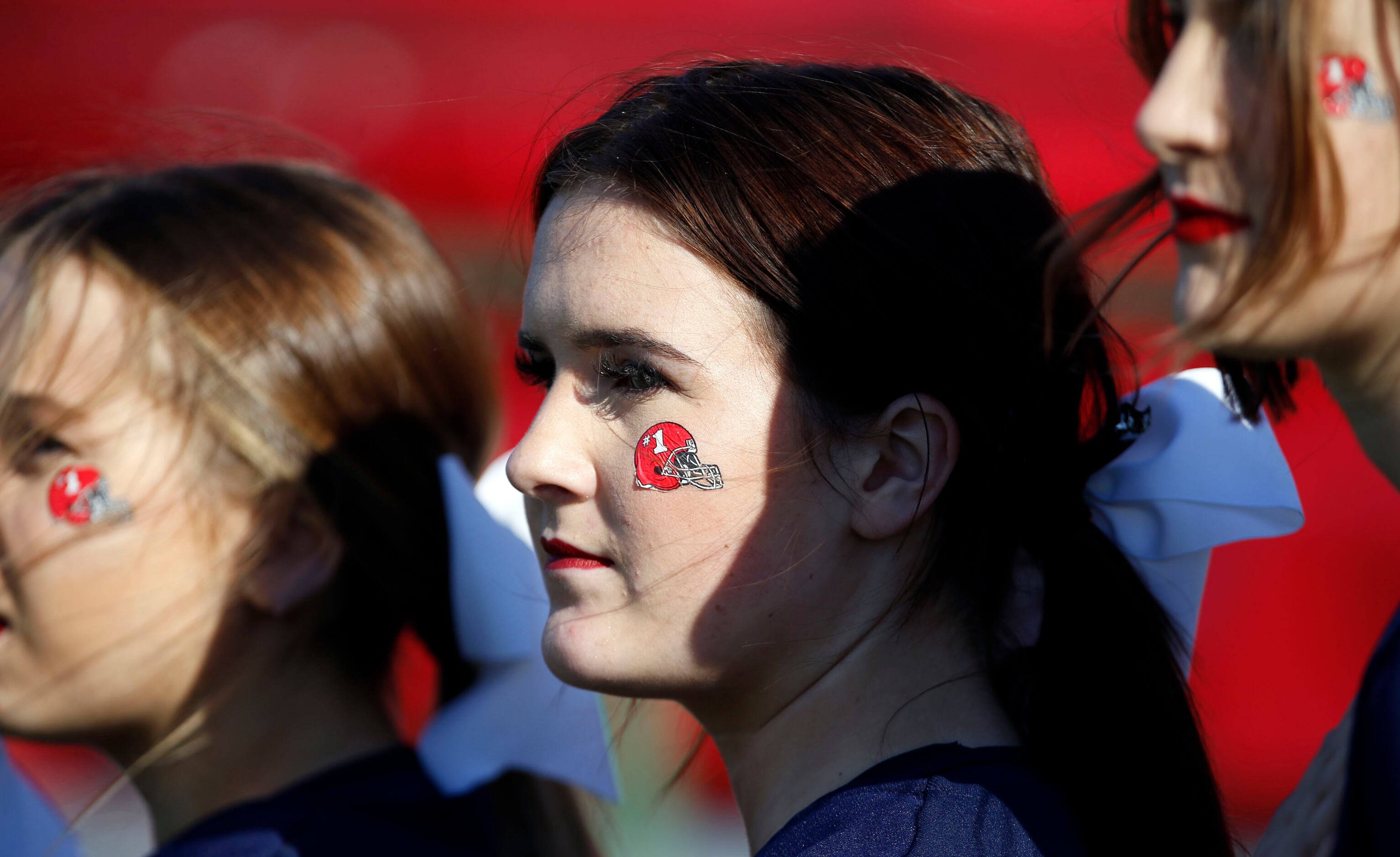 Denton Ryan’s cheerleaders sport “#1” decals on their cheeks during the first half of a...