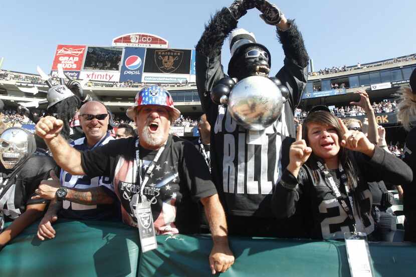 Oakland Raiders fans cheer for their team as they played the Dallas Cowboys in their...