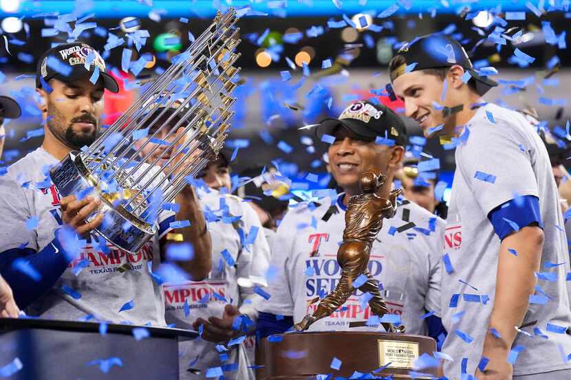 Texas Rangers second baseman Marcus Semien lifts the Commissioner’s Trophy after winning the...