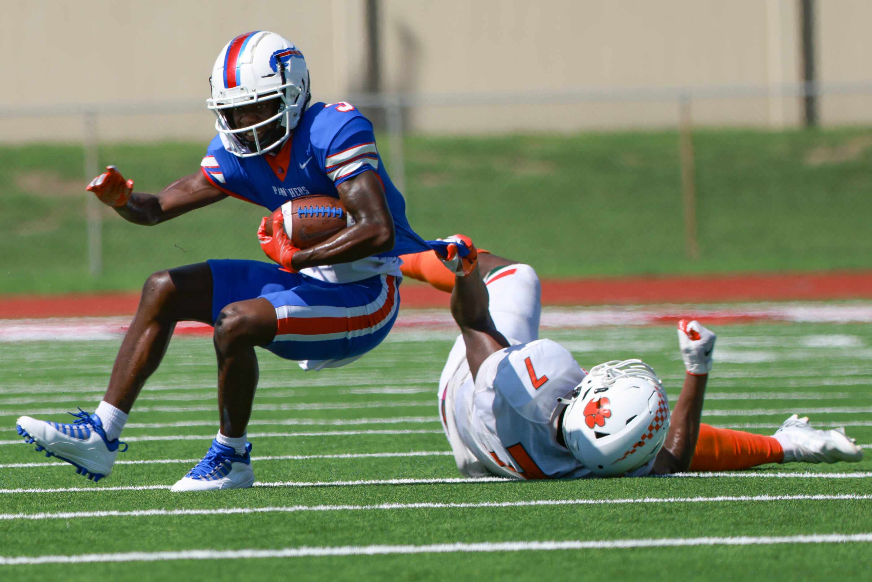 Duncanville High School Lamoderick Spencer (3) gets pulled down by Jones High School Dylan...