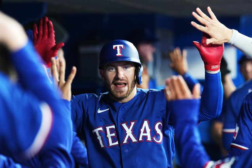 Texas Rangers' Robbie Grossman (4) celebrates his two-run home run against the Toronto Blue...