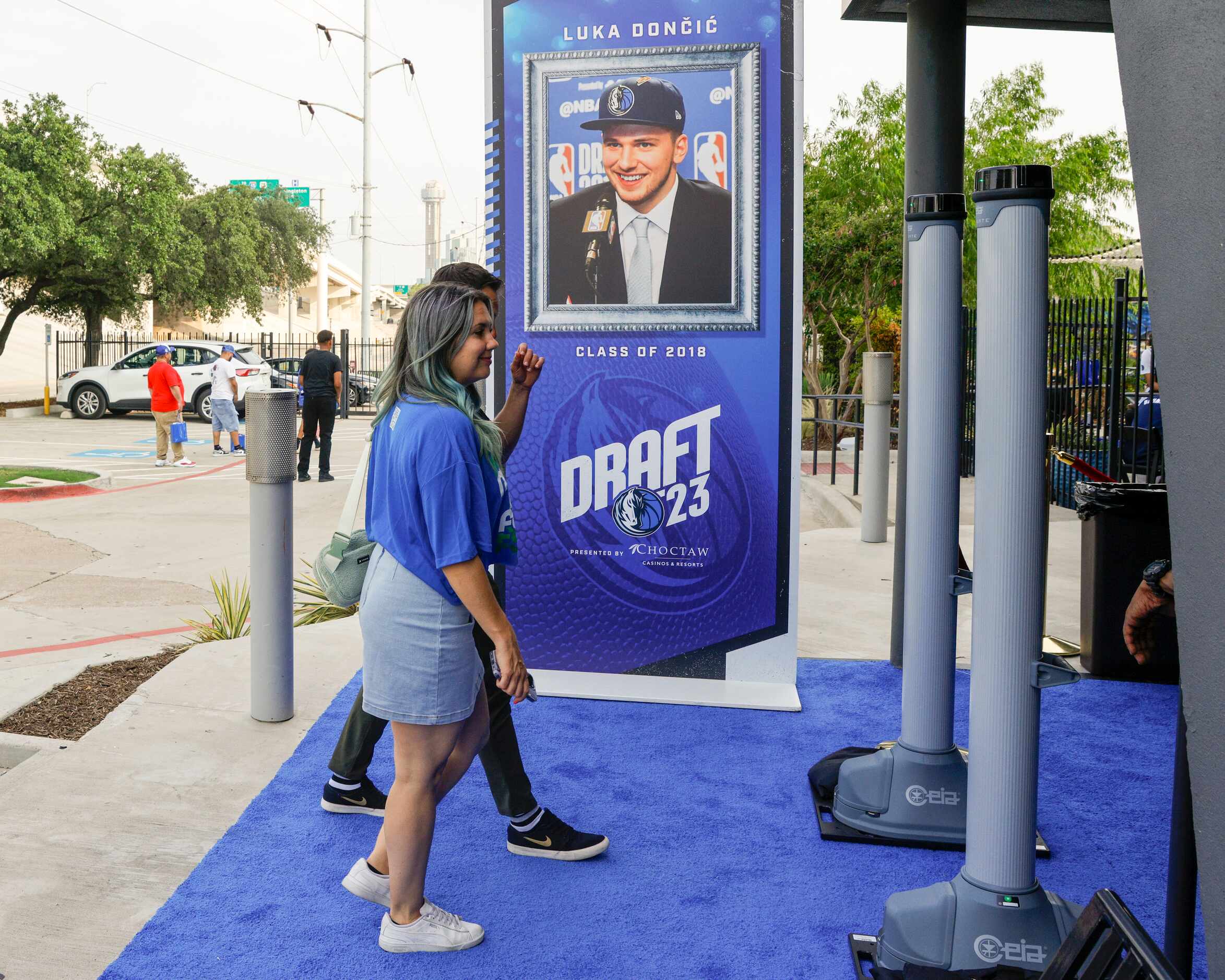 Fans make their way to a Dallas Mavericks 2023 NBA Draft watch party past a photo of Luka...