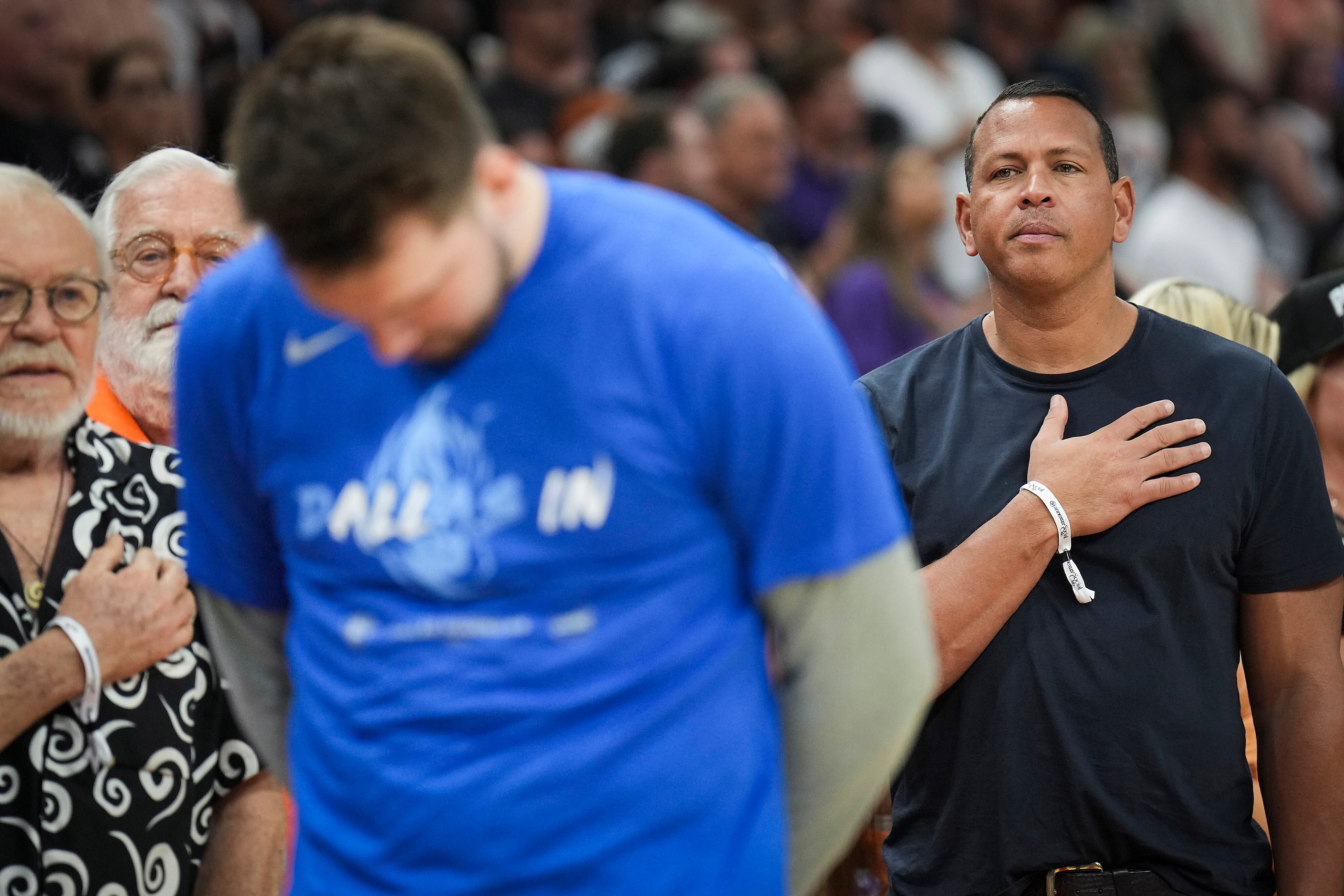 Alex Rodriguez stands for the national anthem behind Dallas Mavericks guard Luka Doncic...