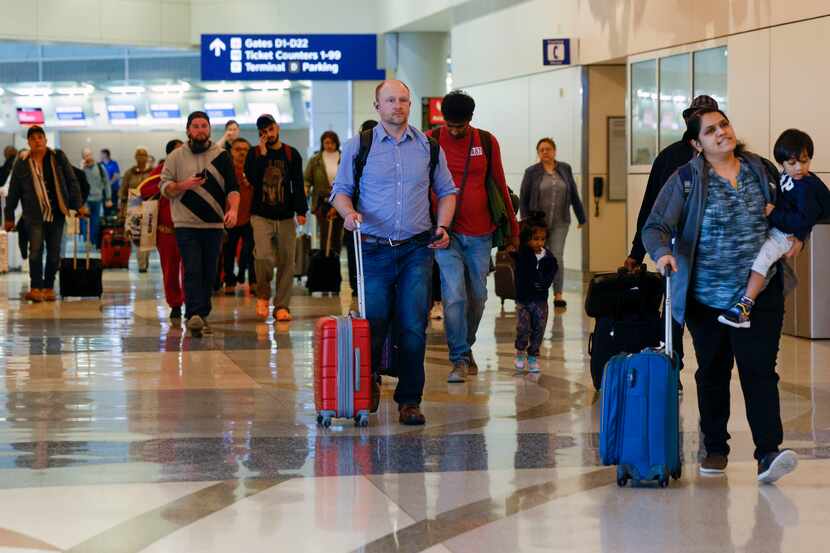Travelers make their way to a security checkpoint inside Terminal D at DFW International...