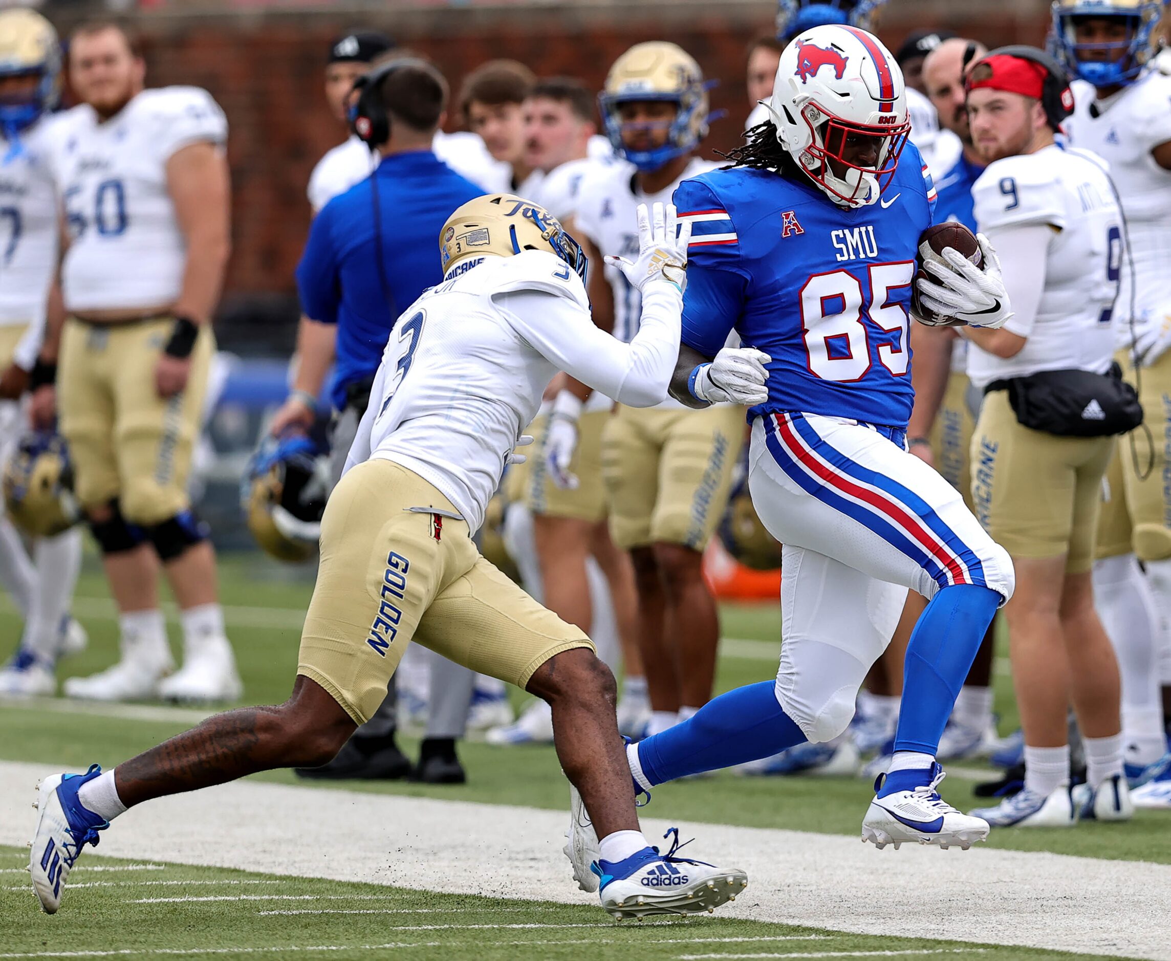 SMU tight end Adam Moore (85) gets pushed out of bounds by Tulsa defensive back Reggie Ellis...