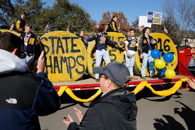 Members of the Highland Park's 5A Division I state championship football team wave at family...