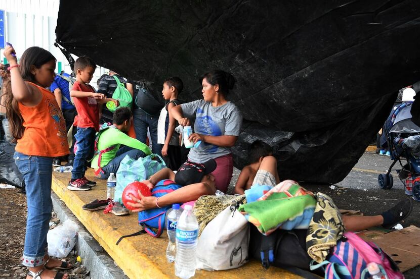 Honduran migrants heading in a caravan to the U.S. wait to cross the border from Ciudad...