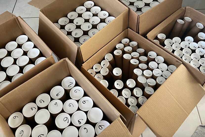 Boxes of poster tubes containing "In God We Trust" posters depicting the national motto in...