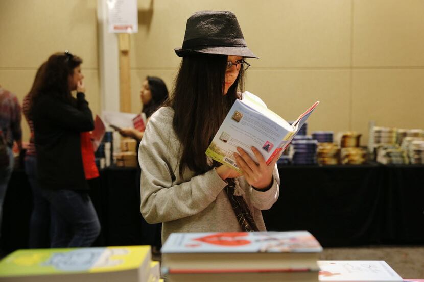 Daja Shelton, 13, of Granbury, Texas, reads a book in a book sale during the North Texas...