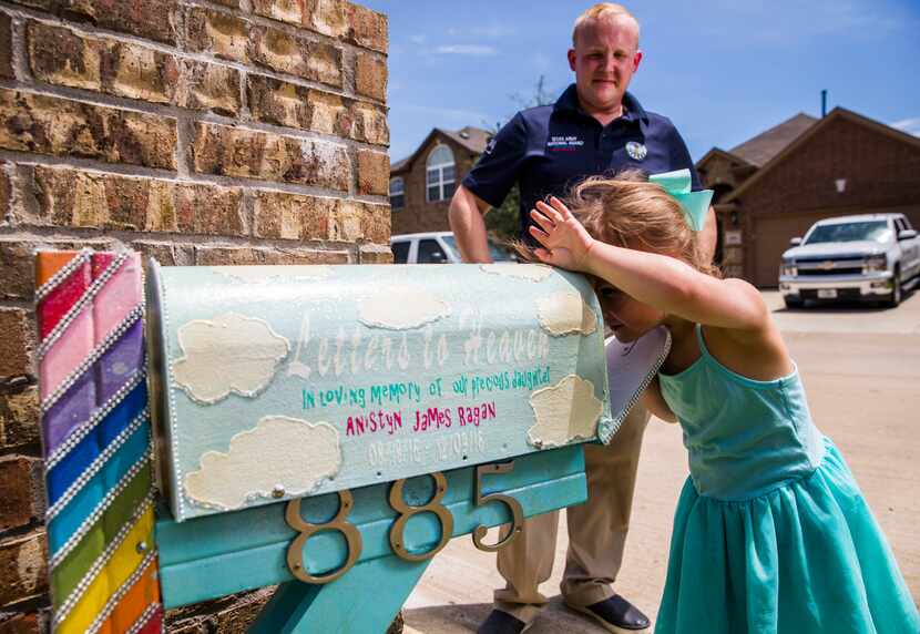 Aviana Ragan, 4, and her father, Joshua Ragan, checks a handmade mailbox for letters on...