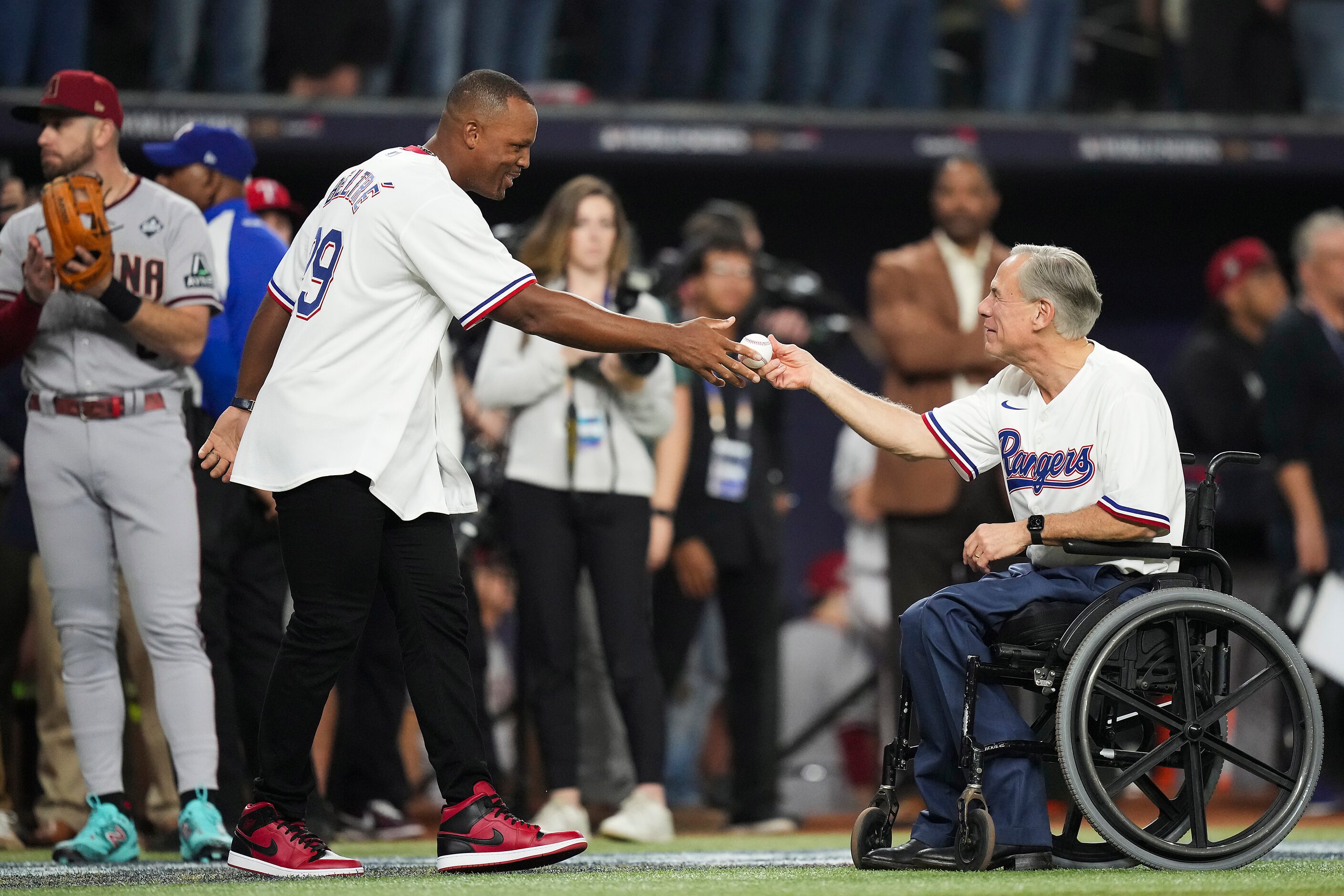 Former Texas Rangers third baseman Adrián Beltré receives a baseball from Governor Greg...