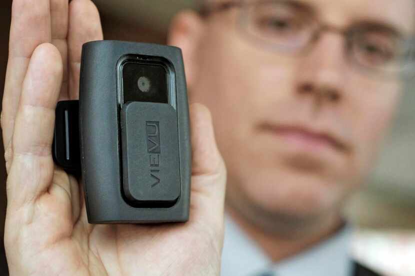Dallas police Sgt. Derek McCarter shows a camera sold by VieVU that is made to be worn on an...