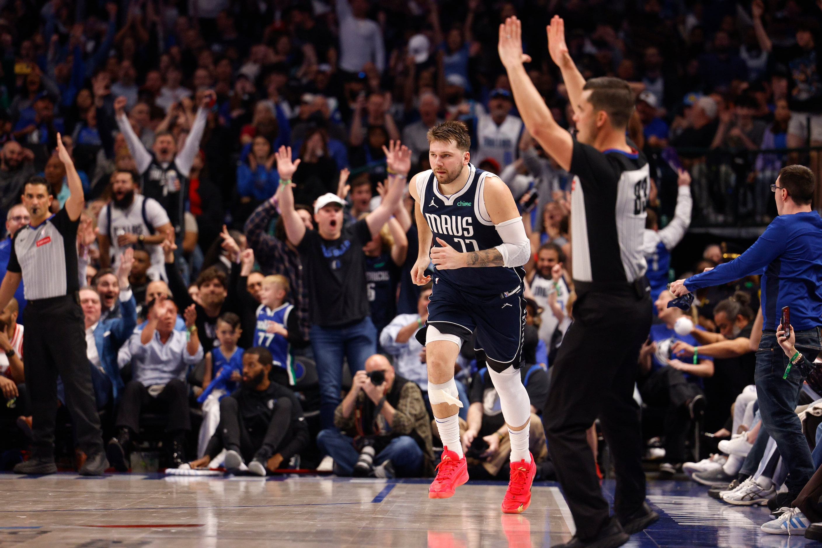 Fans react after Dallas Mavericks guard Luka Doncic (77) made a three-point shot during the...