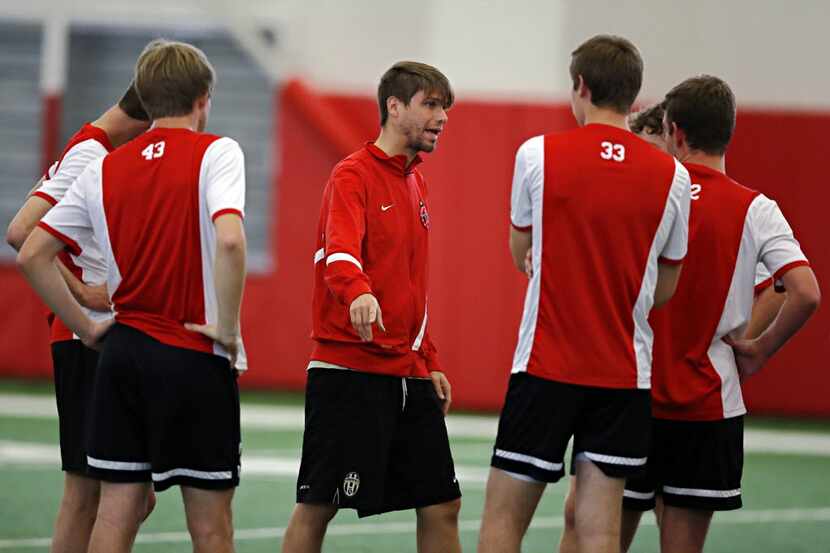 Assistant coach David Blackburn works with players during Coppell soccer practice Wednesday,...