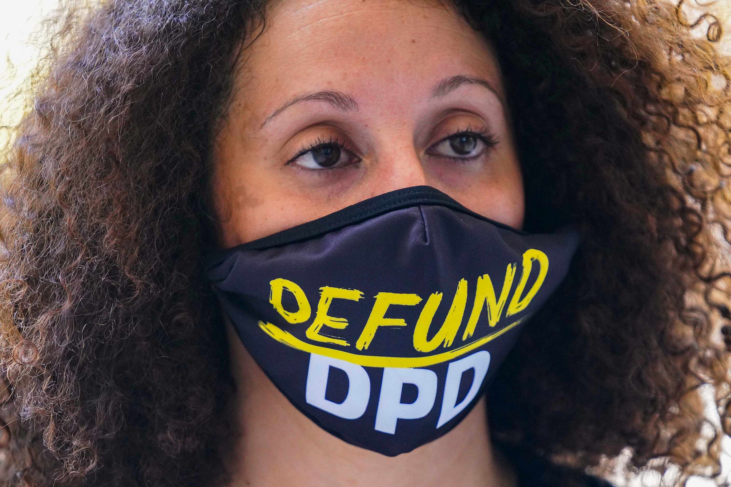 Sara Mokuria of Mothers Against Police Brutality wears a face mask reading 'Defund DPD'...