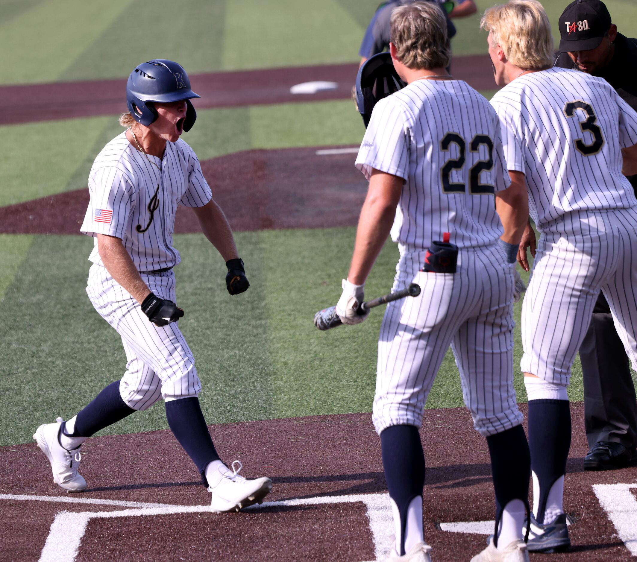 Keller designated hitter Drew Roberts (10), left, lets out a yell as he is met at the plate...