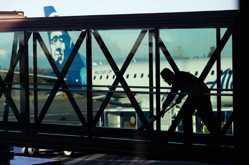 FILE - A worker cleans a jet bridge at Paine Field in Everett, Wash., before passengers...