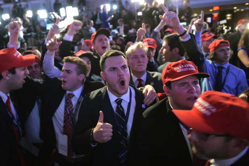 Supporters of Republican presidential nominee Donald Trump reacted to early results during...