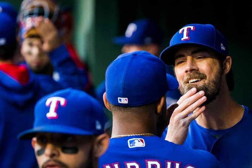 Texas Rangers starting pitcher Cole Hamels rubs his beard in the dugout before a game...