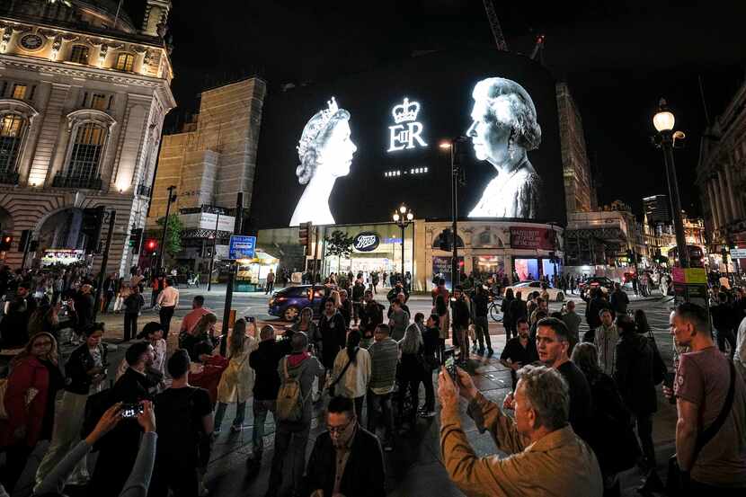 Una pantalla gigante muestra fotografías de la reina Isabel II en Piccadilly Circus, uno de...