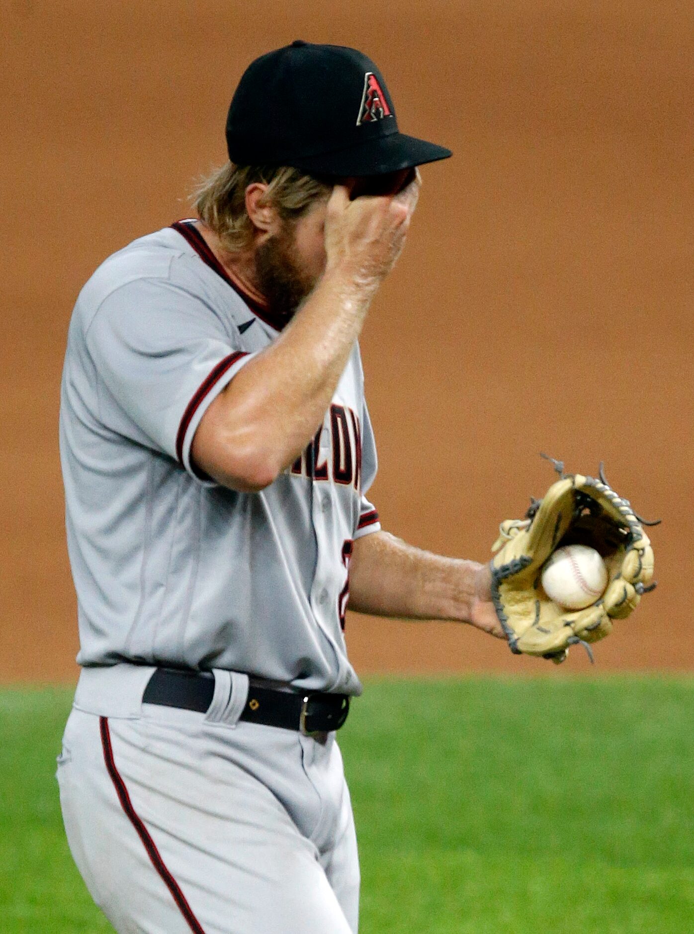 Arizona Diamondbacks starting pitcher Merrill Kelly (29) wipes the sweat from his head after...