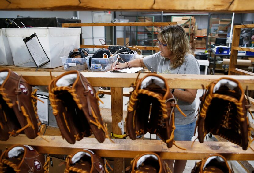 Carla Yeargin of Nocona, Texas works on fulfilling an order for baseball gloves at Nokona in...