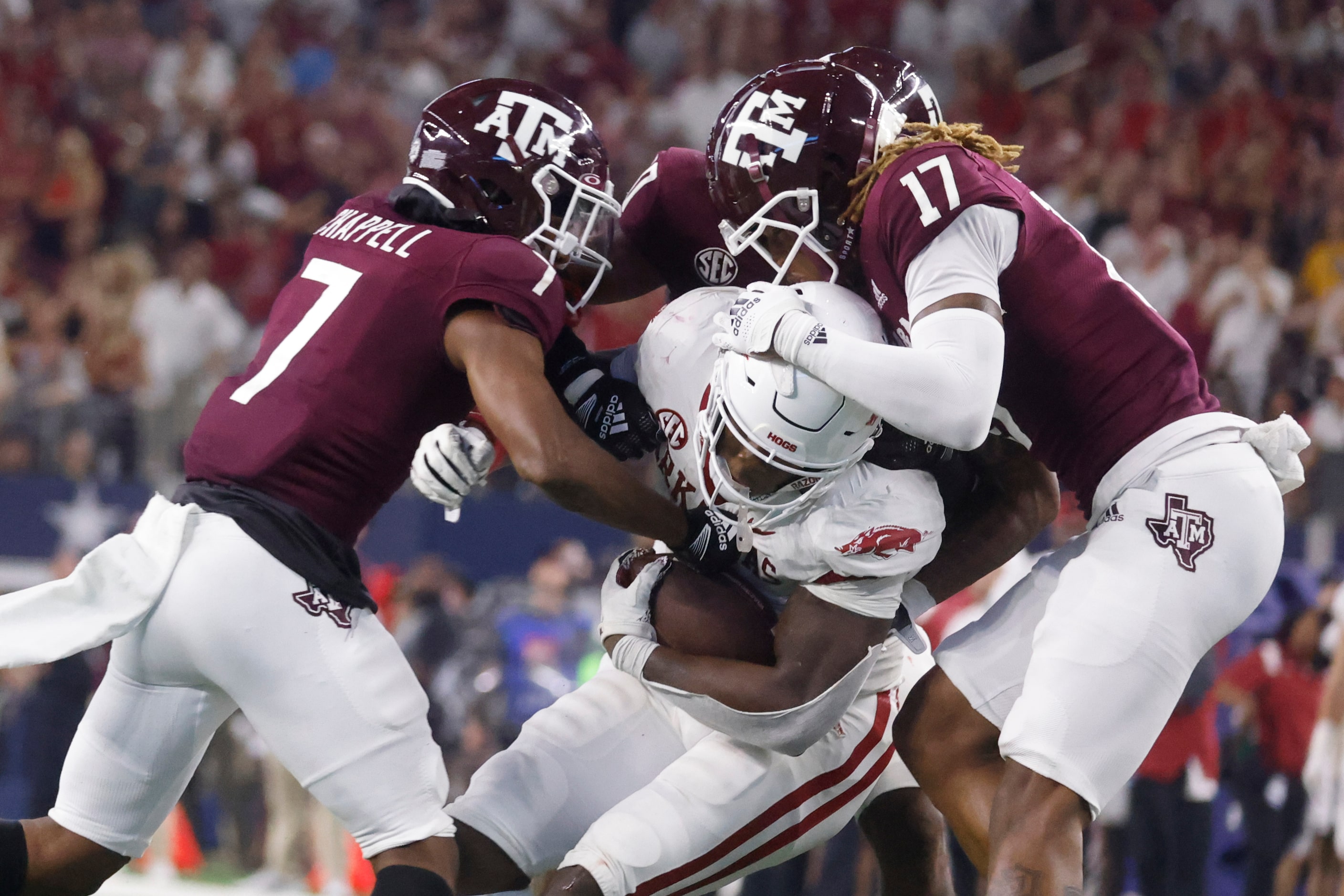 Arkansas running back Raheim Sanders (5), center, gets tackled by DUPLICATE***Texas A&M wide...