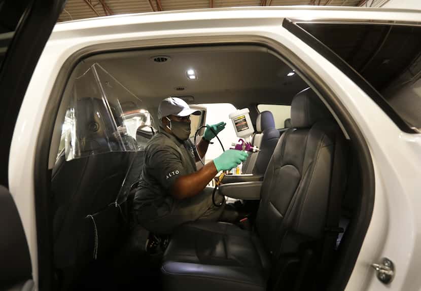 Gregory Brown sprays PermaSafe disinfectant in a vehicle at Alto headquarters in Dallas....
