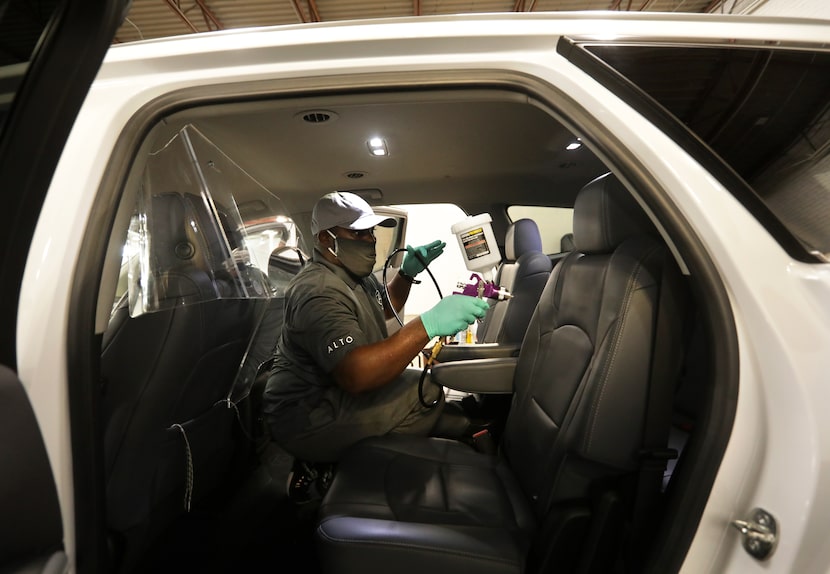 Gregory Brown sprays PermaSafe disinfectant in a vehicle at Alto headquarters in Dallas....