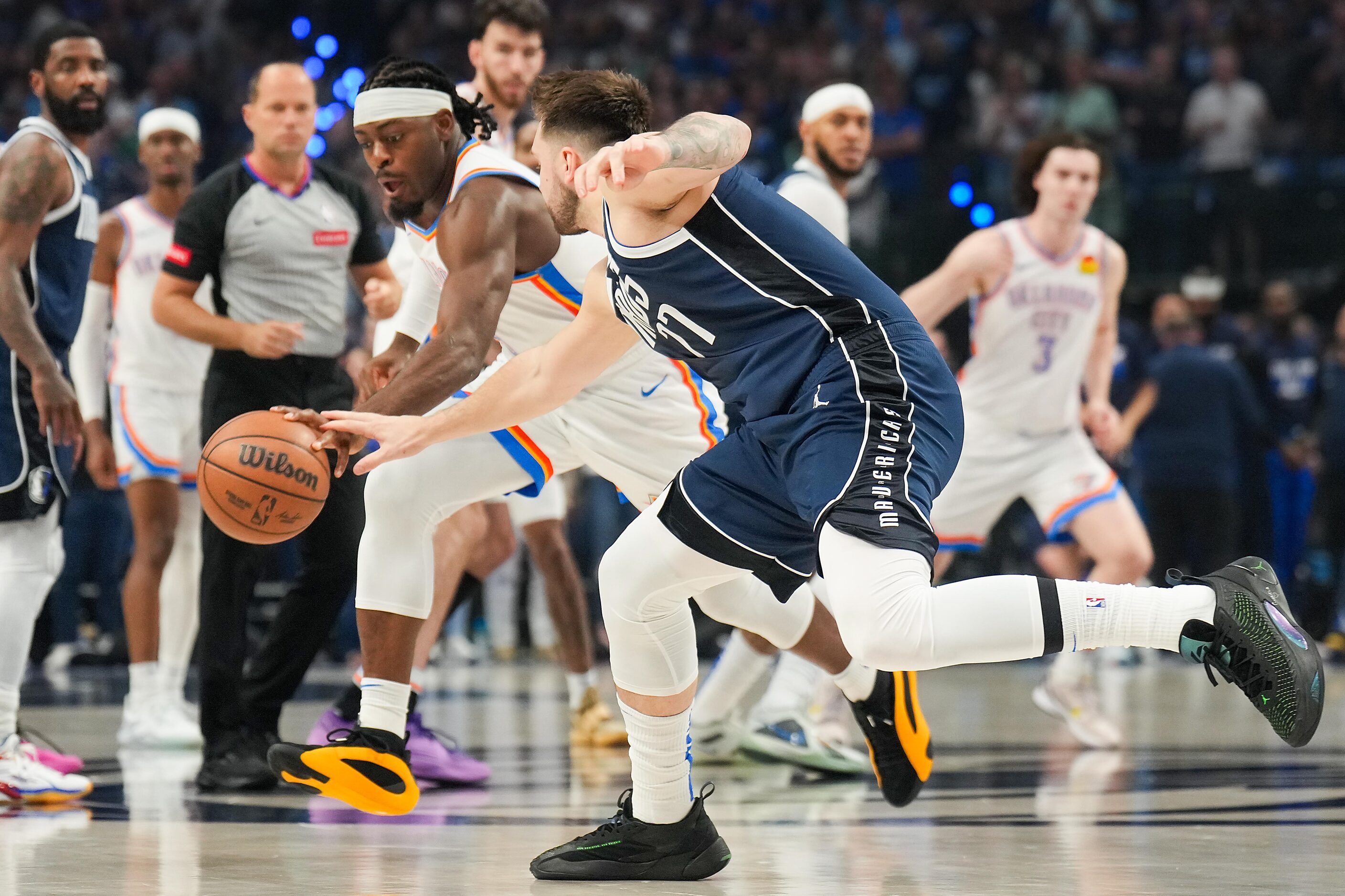 Dallas Mavericks guard Luka Doncic (77) reaches for a loose ball against Oklahoma City...