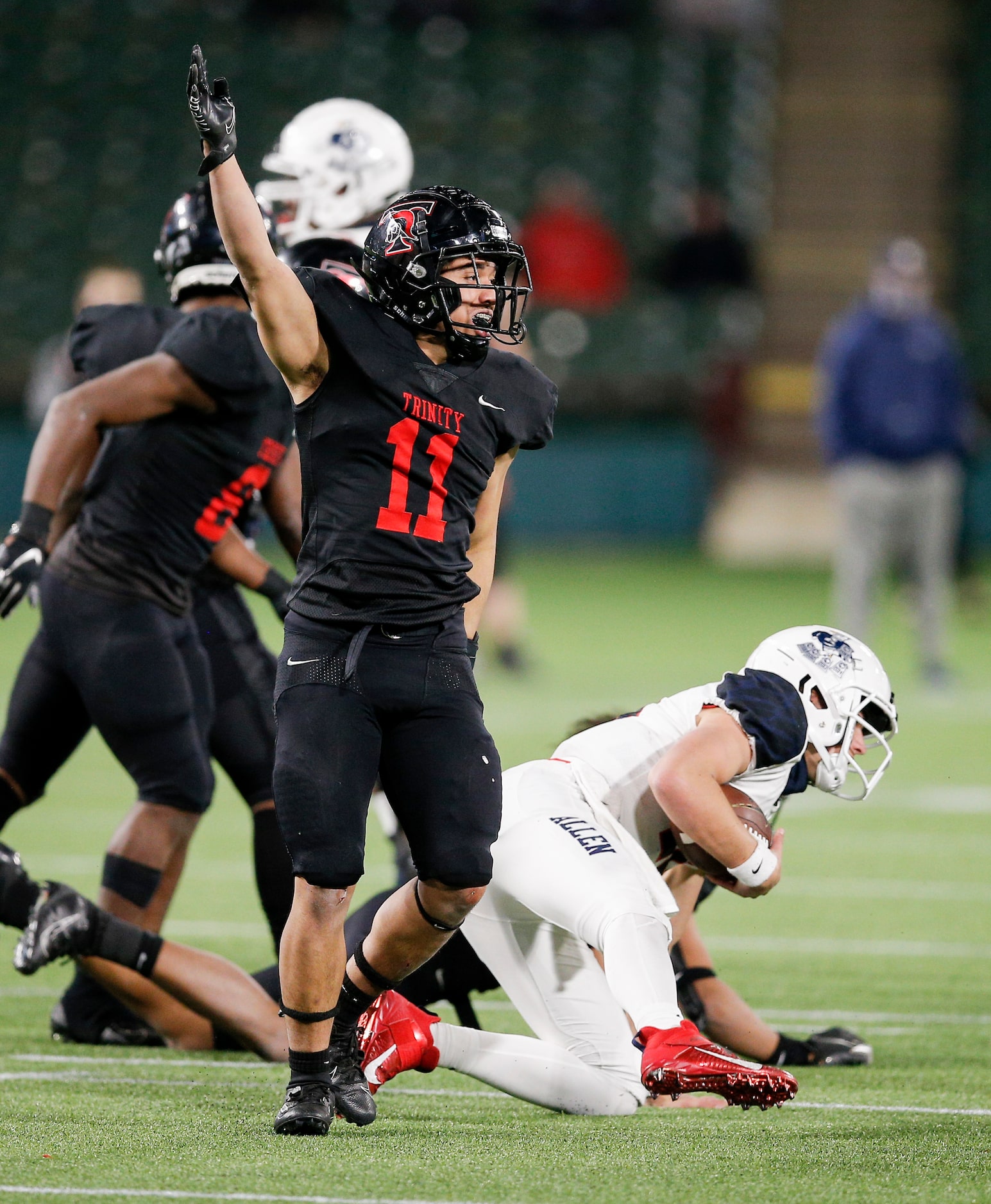 Trinity Euless senior linebacker Sateki Wolfgramm (11) celebrates tackling Allen senior...