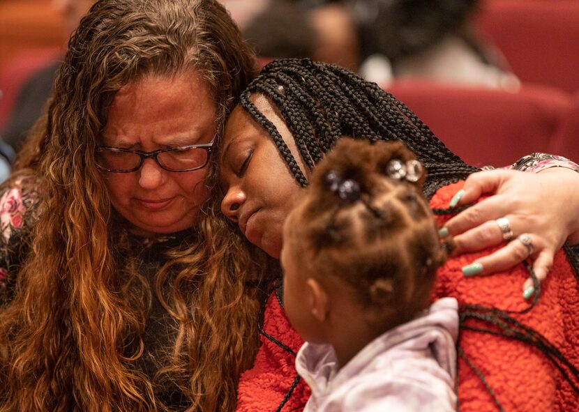 Cheryl Coyle wraps her arm around Tamyah Wells while Ahlana Brown sits on her lap during the...