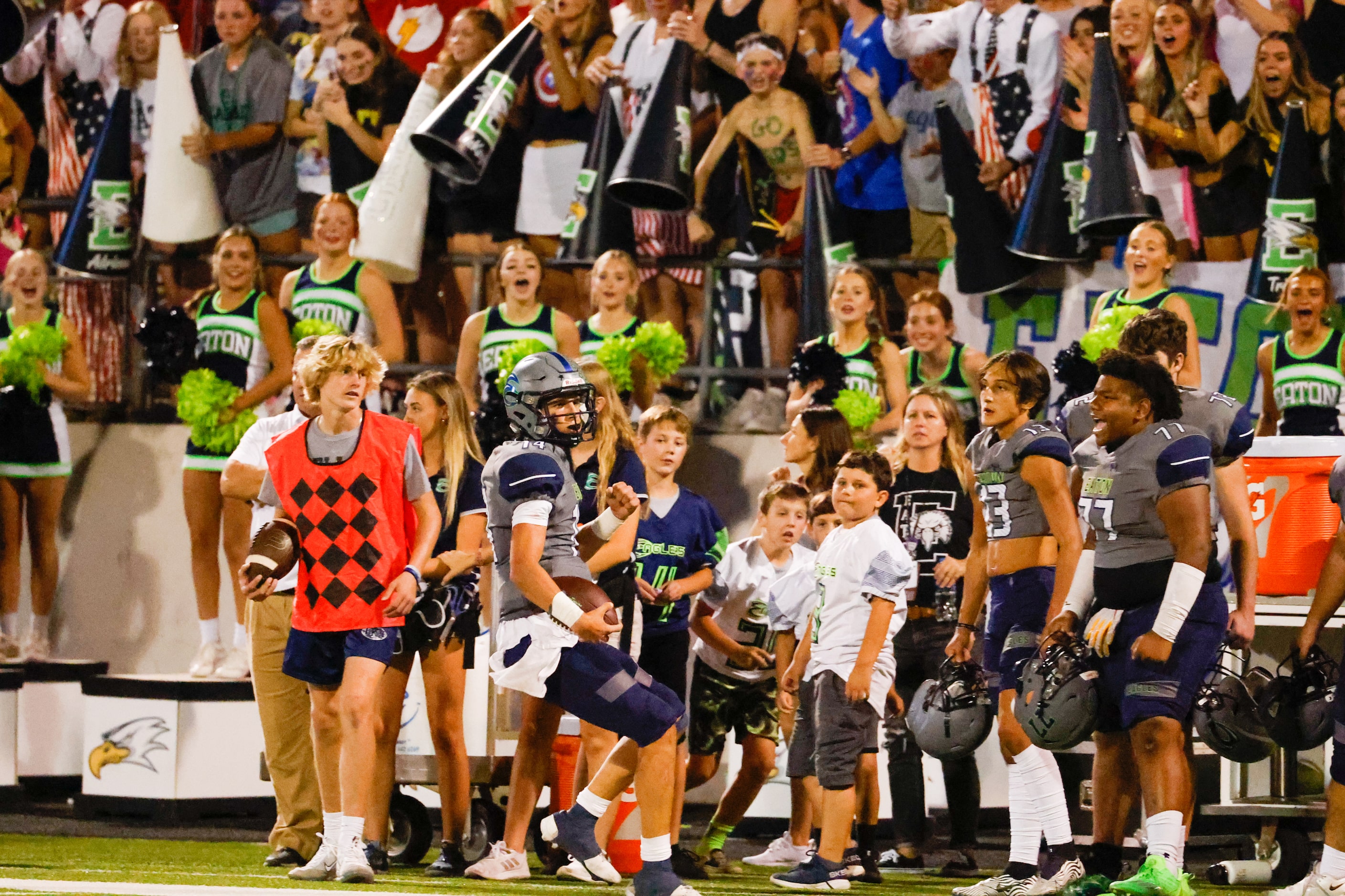 V.R. Eaton High School quarterback Noah Lugo (14) pumps his fist as he runs out of bounds...