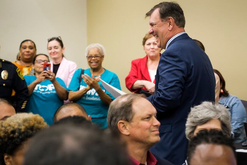 Dallas Mayor Mike Rawlings is applauded by people in the crowd after he received a...