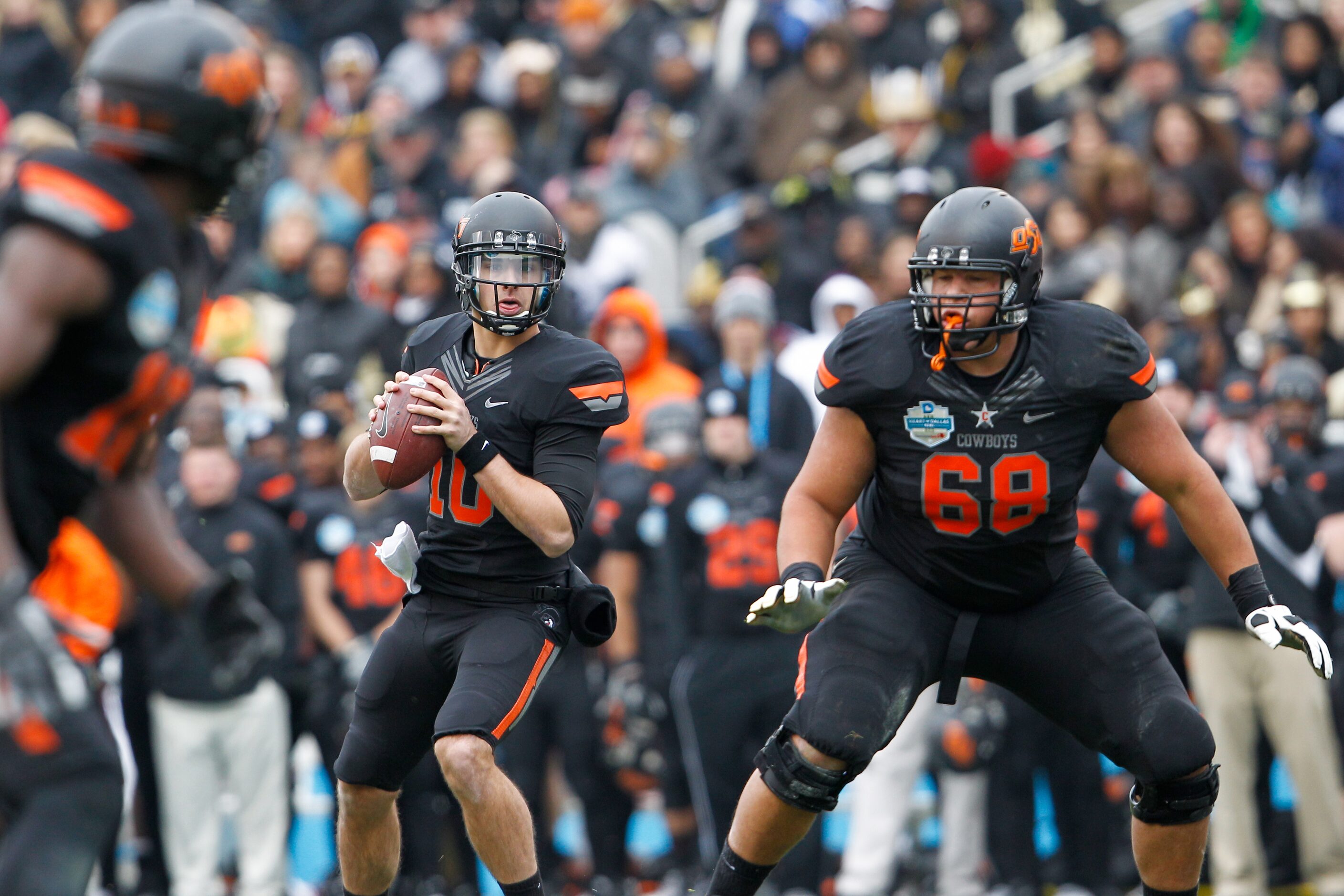 Oklahoma State's Clint Chelf (10) looks for an open receiver during the inaugural Heart of...