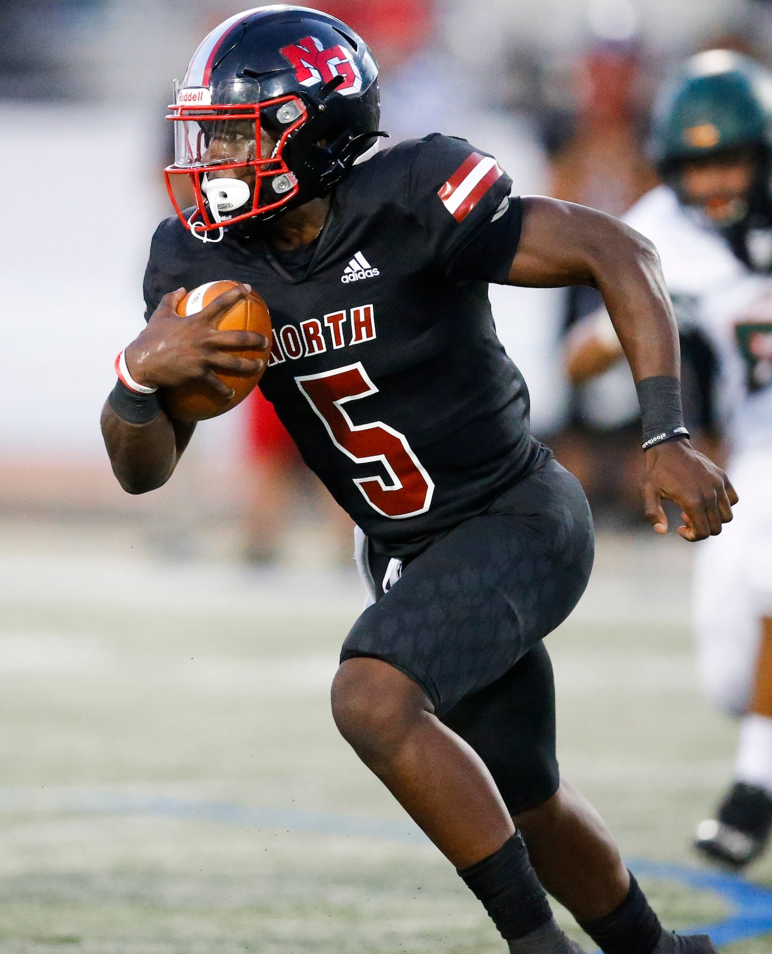 North Garland sophomore quarterback Godspower Nwawuihe carries the ball during a high school...