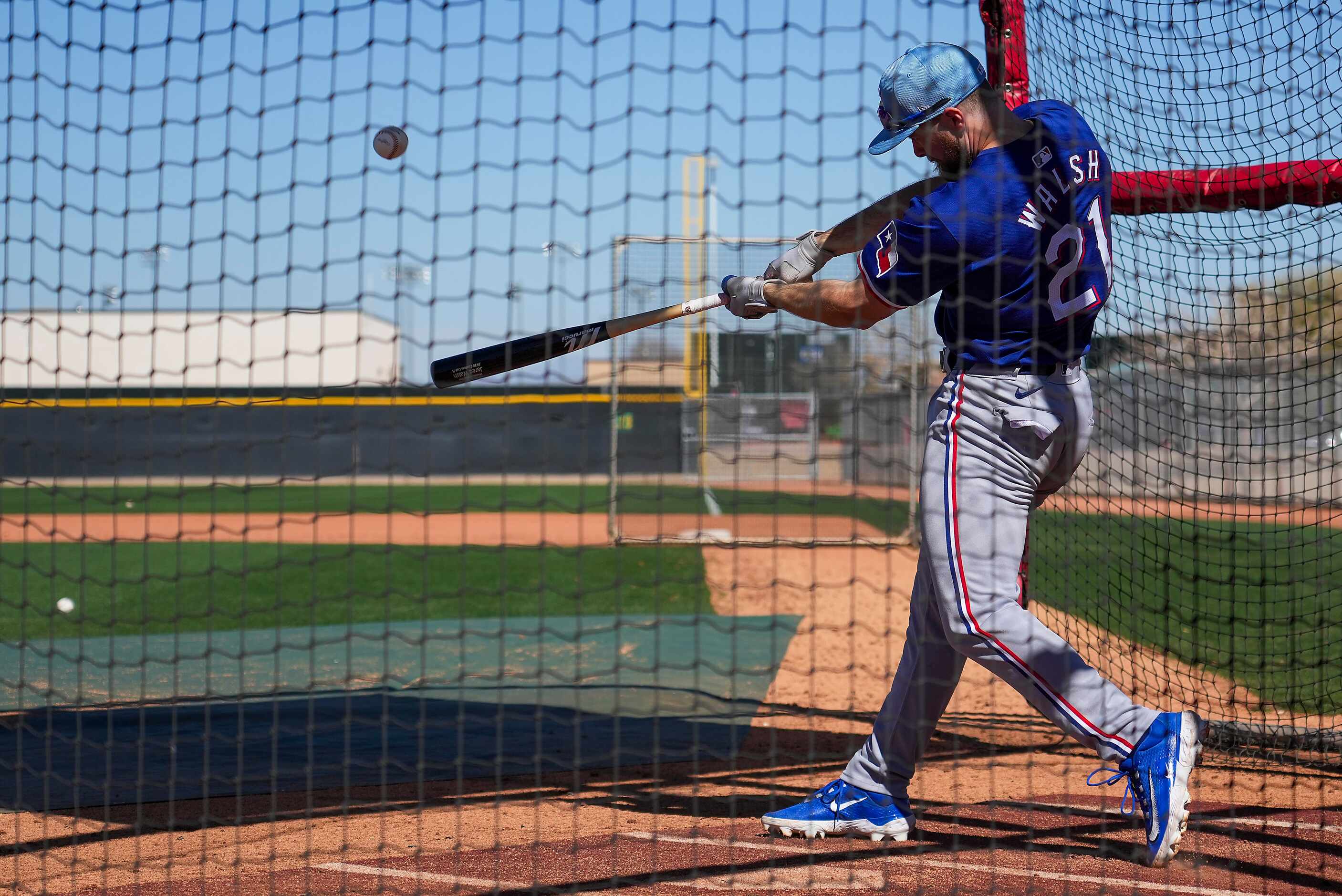 Texas Rangers infielder Jared Walsh takes batting practice during the first full squad...