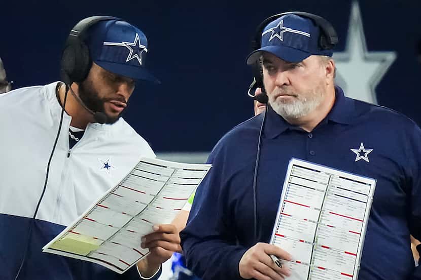 Dallas Cowboys quarterback Dak Prescott calls in a play next to head coach Mike McCarthy...