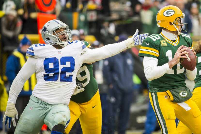 Green Bay Packers quarterback Aaron Rodgers (12) slips away from Dallas Cowboys defensive...