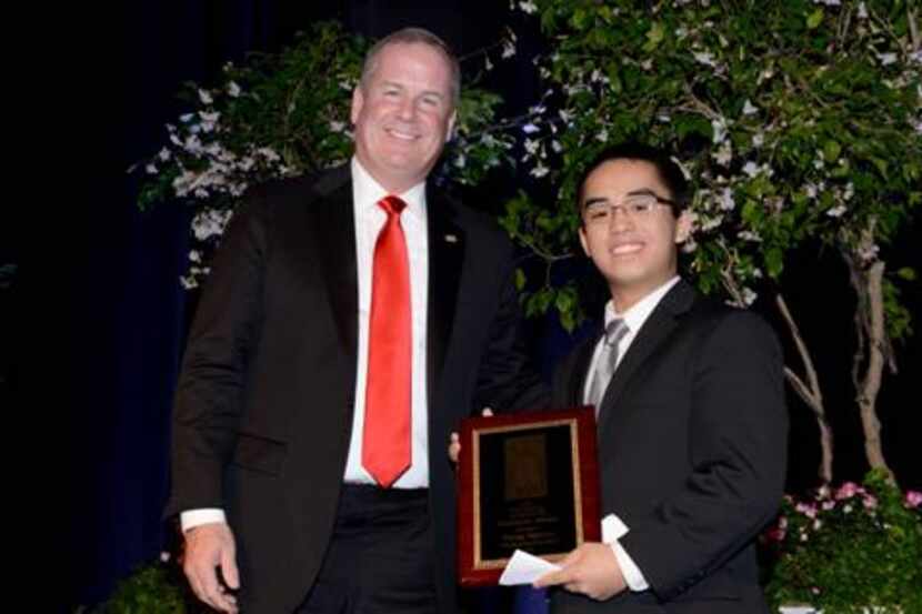 Matt Kramer, president and CEO of the Catholic Foundation, presents a Scholar Award to Phong...
