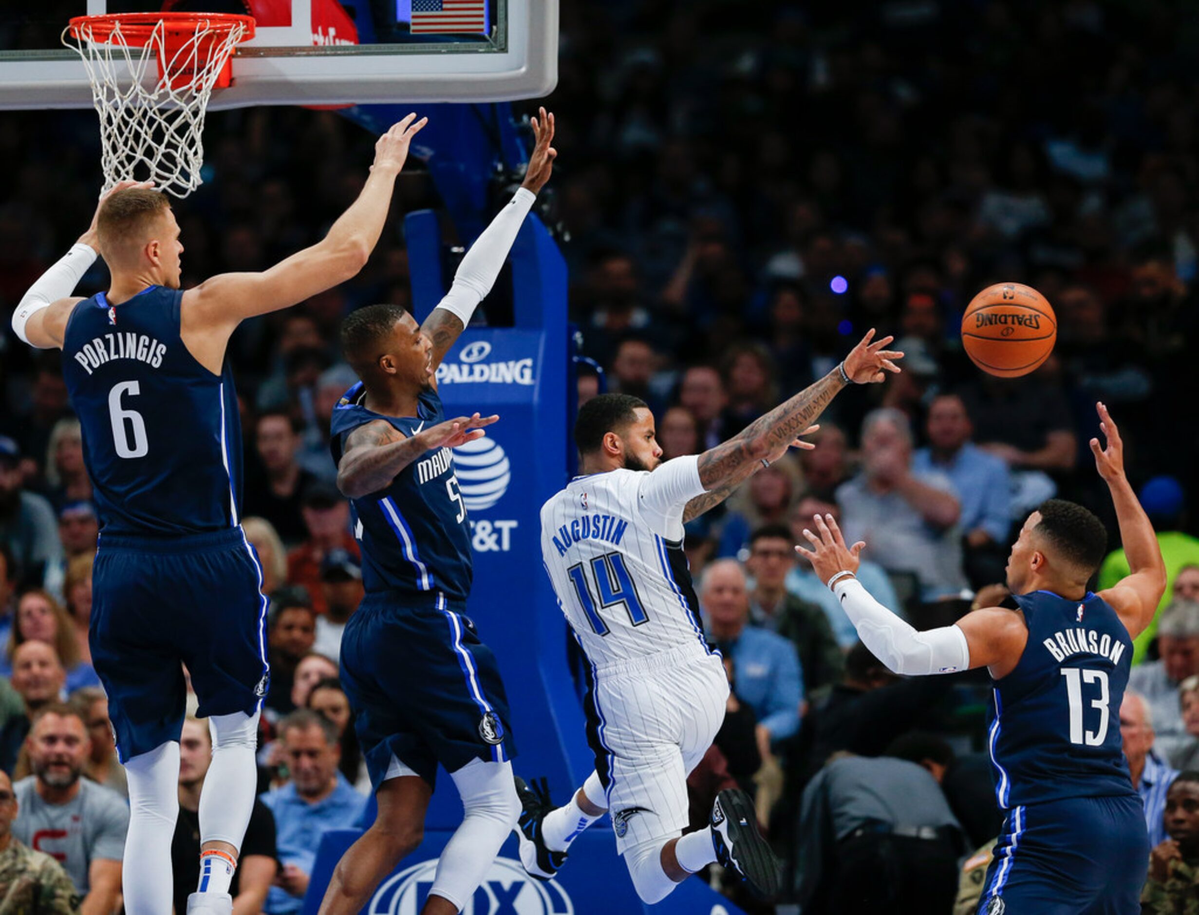 Orlando Magic guard D.J. Augustin (14) passes overtop Dallas Mavericks guard Jalen Brunson...