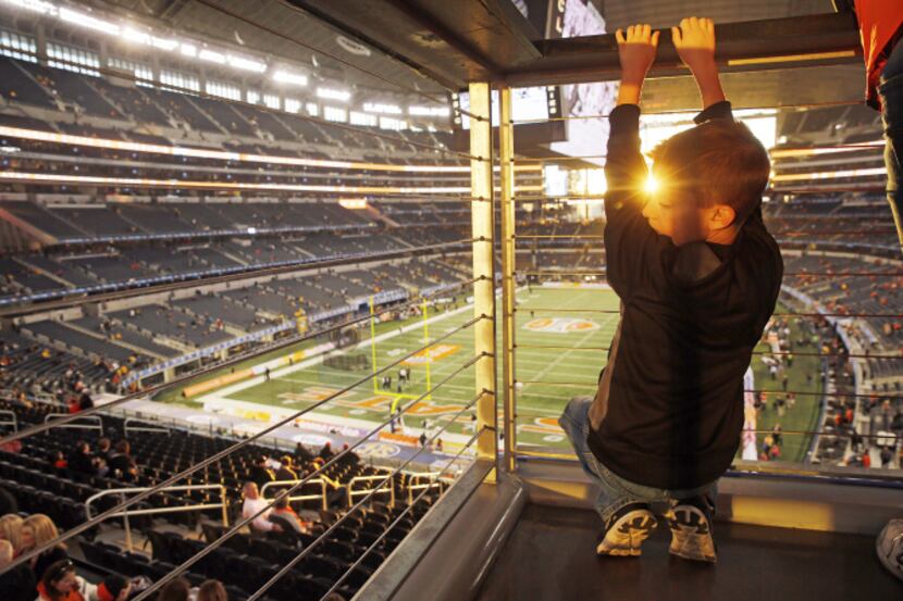 Kolbe Fielder, 8, of Hurst hung out on a stairwell of AT&T Stadium as fans filed in for the...