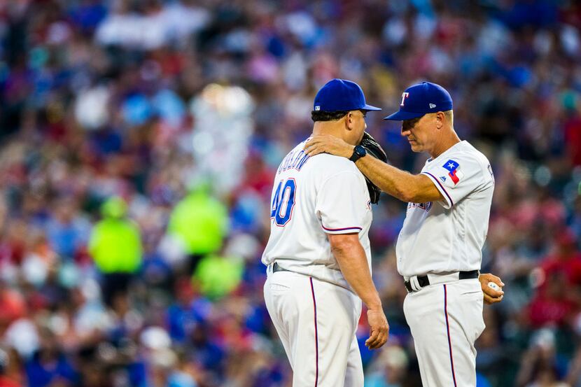 Texas Rangers manager Jeff Banister (28) takes the ball rom Texas Rangers starting pitcher...