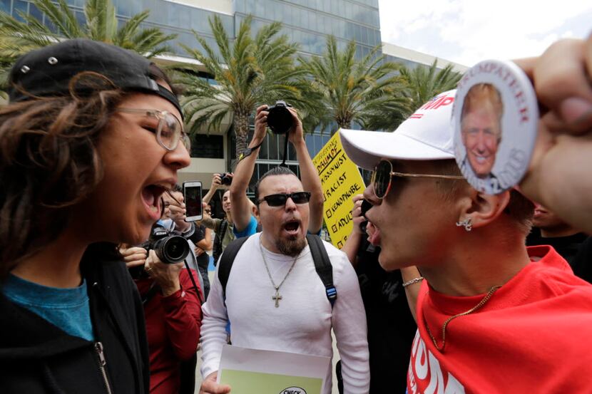 Donald Trump supporter Jake Towe (right) faces off with anti-Trump protester Joshua Gonzalez...