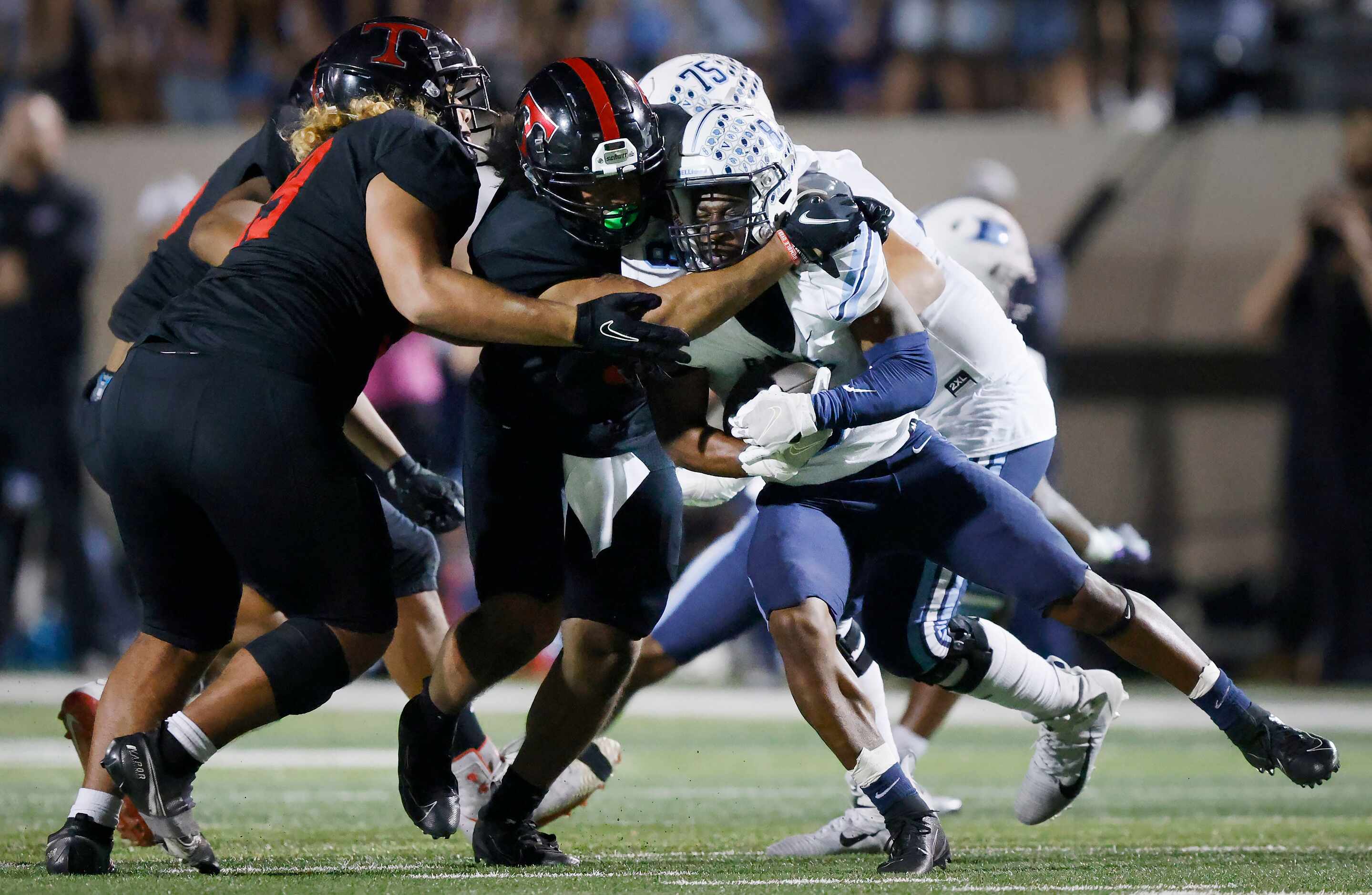 Hurst L.D. Bell running back Gracien Anto (8) is stopped by Euless Trinity linebacker Corey...