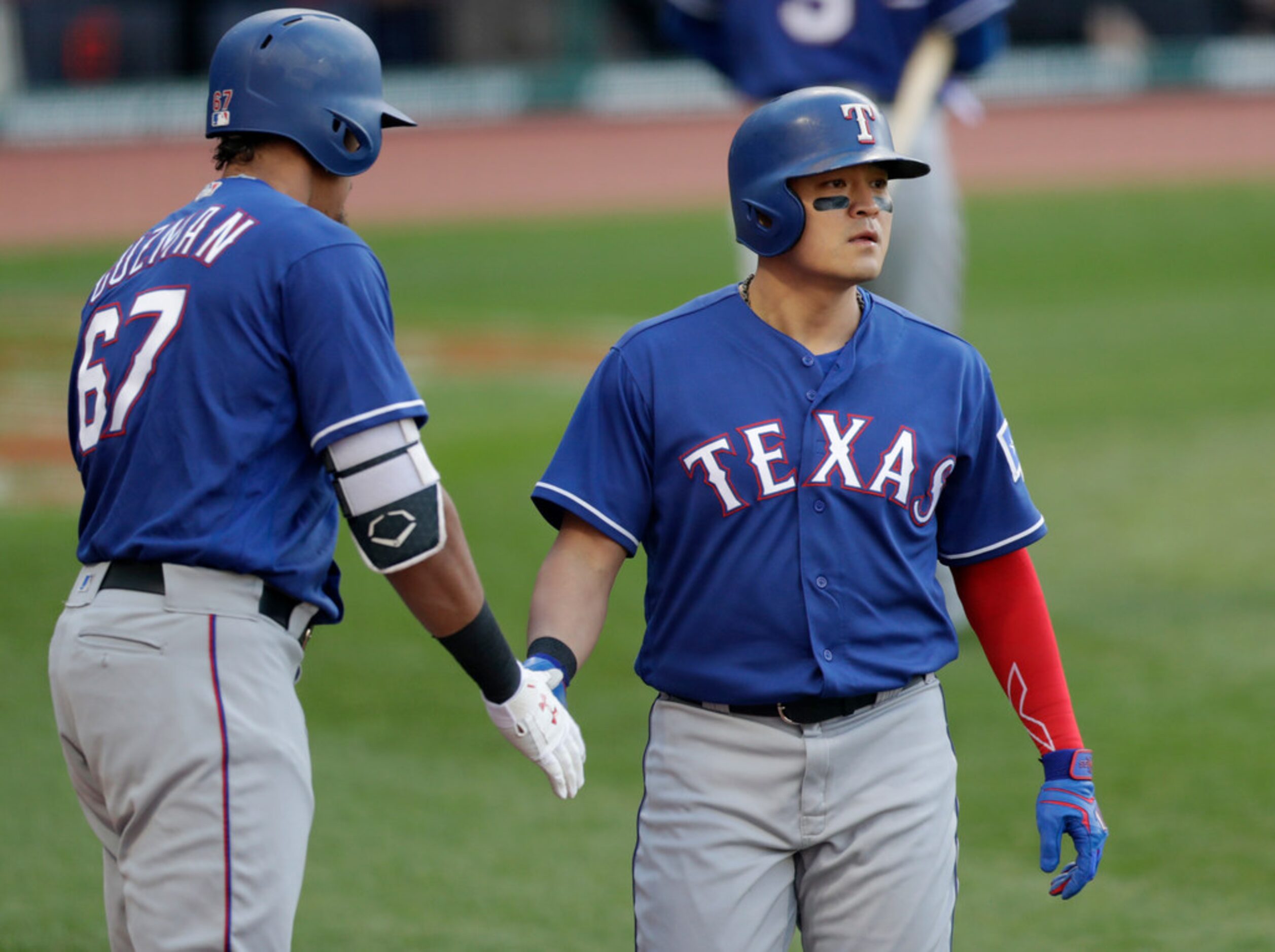 Texas Rangers' Shin-Soo Choo, right, is congratulated by Ronald Guzman after scoring in the...