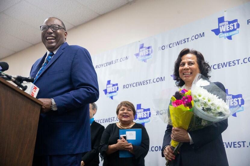 State Senator Royce West, left, laughs after handing flowers to his wife Carol West, right,...